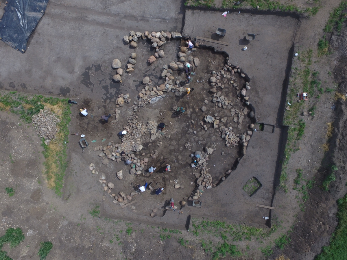 Der Kern des Grabhügels bestand aus einem mächtigen Steinmantel, unter dem sich die hölzerne Grabkammer befand. Sie war mindestens 2,5 Meter hoch und maß ungefähr 6 x 3,5 Meter. Das Holz der Konstruktionselemente war bereits vergangen, ließ sich aber über Abdrücke im Boden identifizieren. Die Grabkammer wurde bereits in prähistorischen Zeiten beraubt. © Landesamt für Denkmalpflege und Archäologie Sachsen-Anhalt, Thomas Koiki.